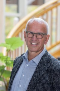 Man in a patterned blazer indoors.