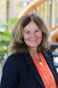 Woman in orange shirt and blazer