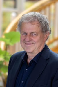 Man in a suit with greenery.