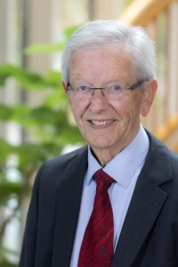 Elderly man in formal attire.