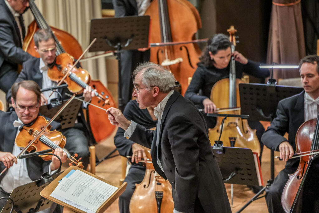 Conductor leading an orchestra performance.